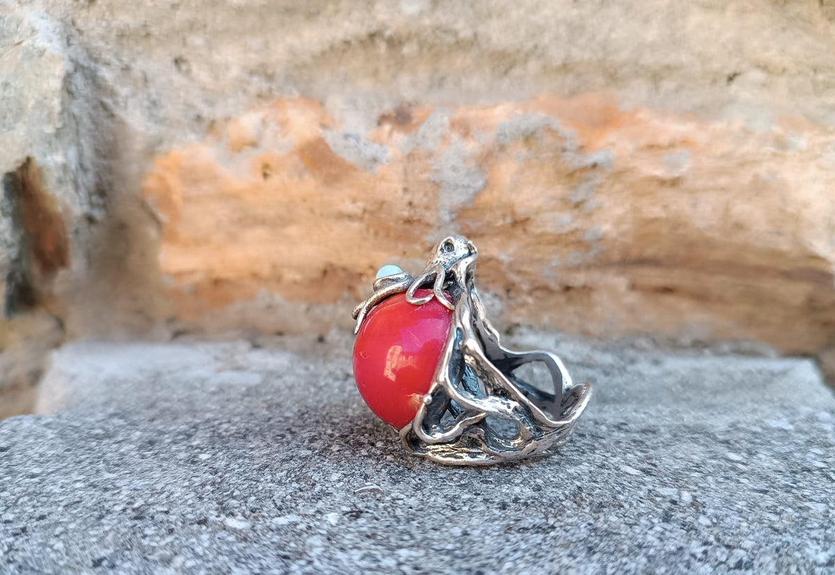 anello scultura oceanica con tentacoli di polpo in argento, sfera di corallo rosso e due opali bianchi