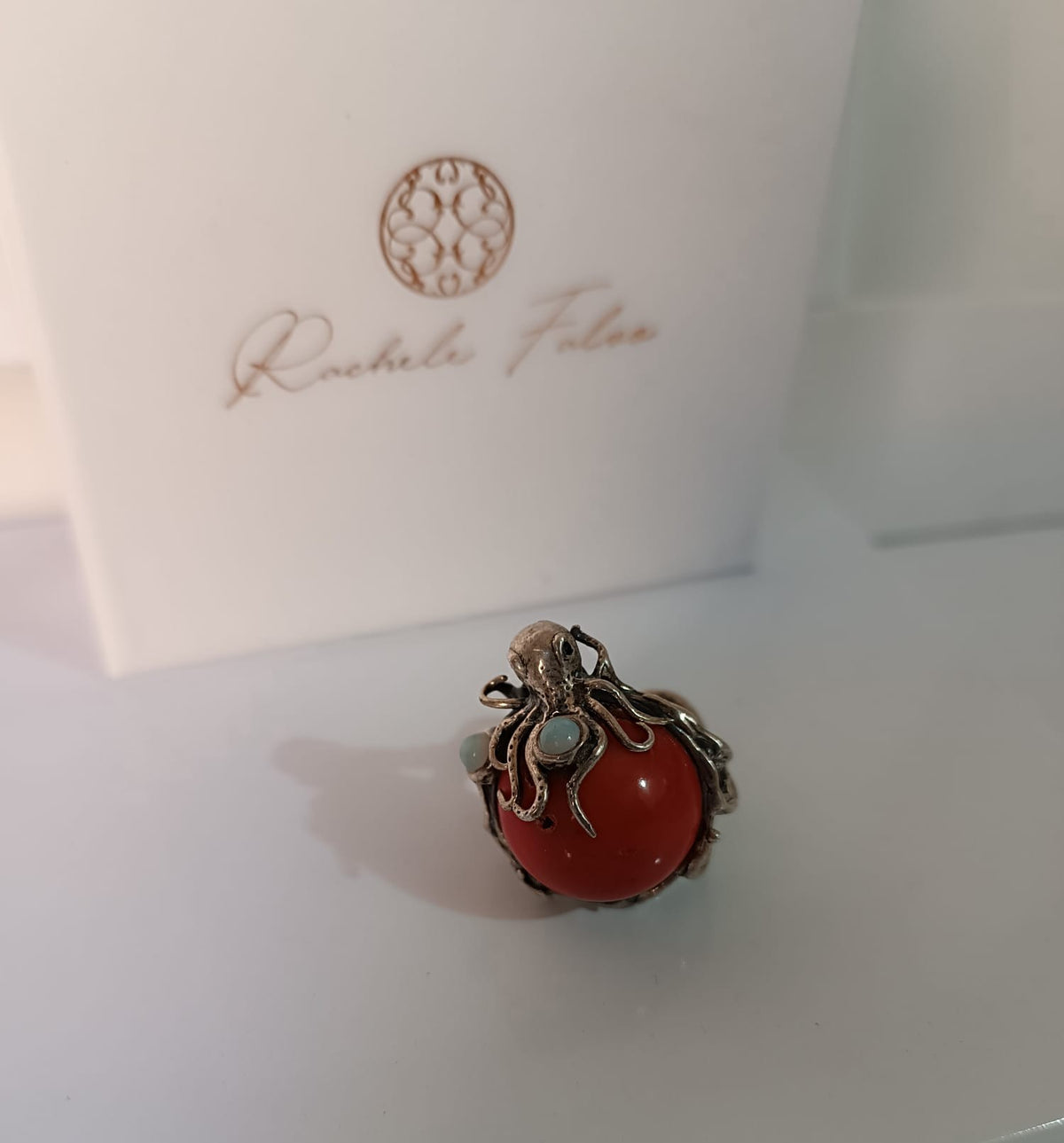 anello scultura oceanica con tentacoli di polpo in argento, sfera di corallo rosso e due opali bianchi