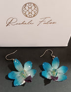 orecchini pendenti artigianali con piccole orchidee vere in resina trasparente colore  azzurro, con ganci in argento.