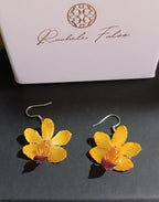 orecchini pendenti artigianali con piccole orchidee vere in resina trasparente colore  giallo, con ganci in argento.