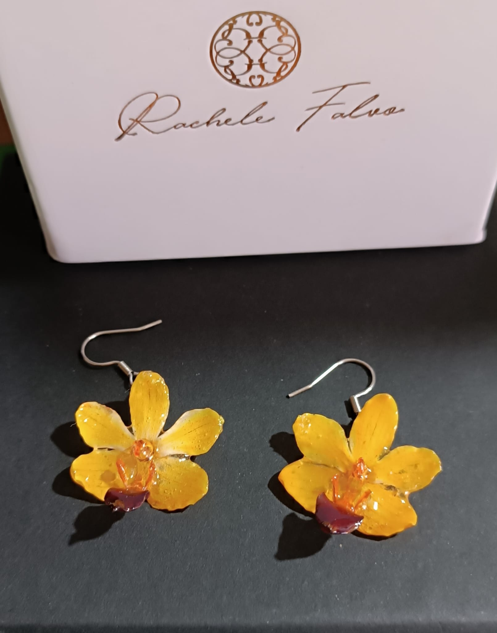 orecchini pendenti artigianali con piccole orchidee vere in resina trasparente colore  giallo, con ganci in argento.