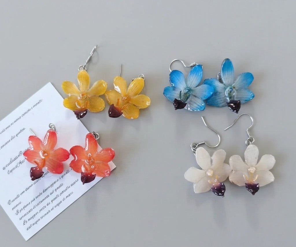 orecchini pendenti artigianali con piccole orchidee vere in resina trasparente colori disponibili   arancione, azzurro, bianco, giallo, con ganci in argento.