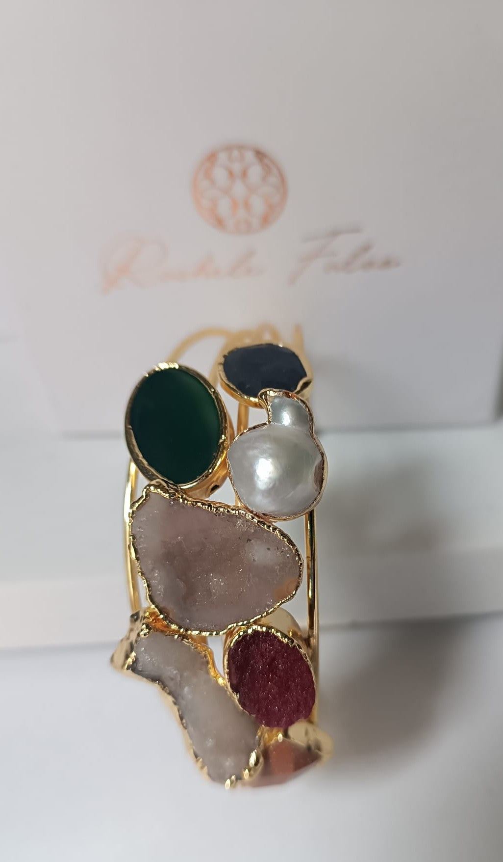 bracciale cuff dorato multifilo di Rachele Falvo con incastonati una perla barocca, un rubino grezzo, agate naturali e un'avventurina sfaccettata