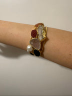 bracciale cuff dorato multifilo di Rachele Falvo con incastonati una perla barocca, un rubino grezzo, agate naturali e un'avventurina sfaccettata