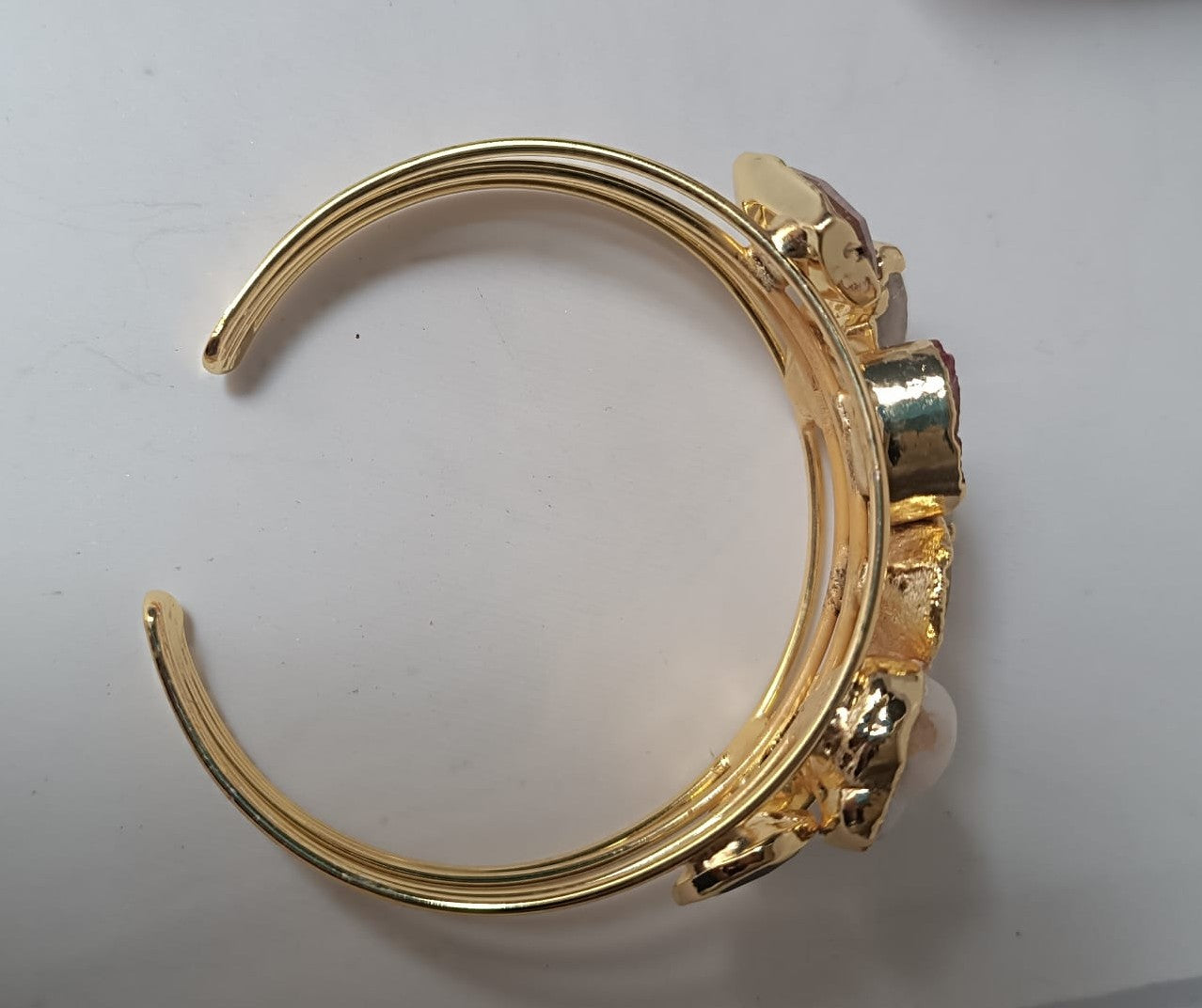 bracciale cuff dorato multifilo di Rachele Falvo con incastonati una perla barocca, un rubino grezzo, agate naturali e un'avventurina sfaccettata