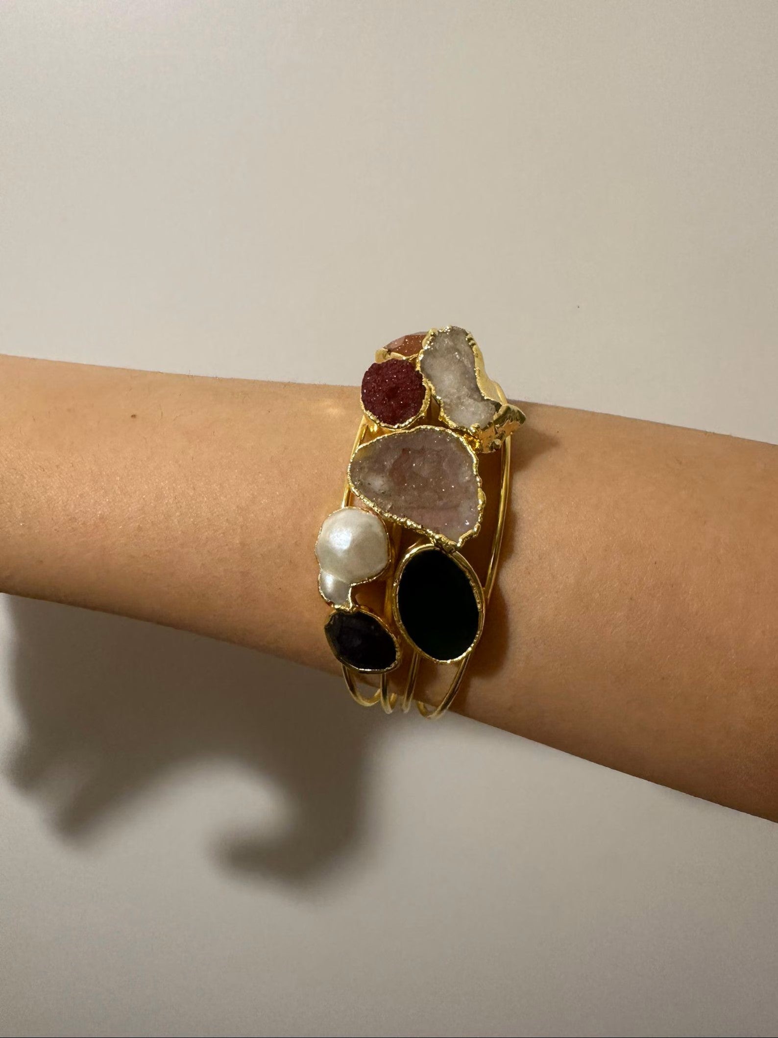 bracciale cuff dorato multifilo di Rachele Falvo con incastonati una perla barocca, un rubino grezzo, agate naturali e un'avventurina sfaccettata