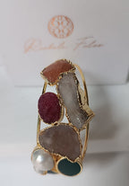bracciale cuff dorato multifilo di Rachele Falvo con incastonati una perla barocca, un rubino grezzo, agate naturali e un'avventurina sfaccettata
