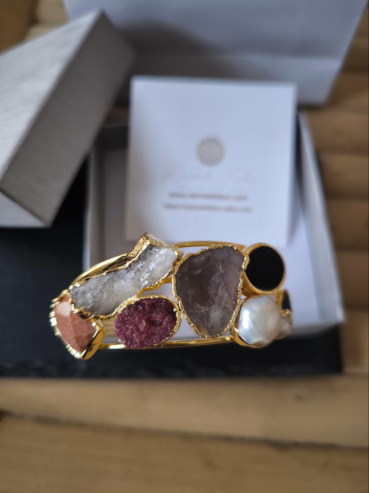 bracciale cuff dorato multifilo di Rachele Falvo con incastonati una perla barocca, un rubino grezzo, agate naturali e un'avventurina sfaccettata