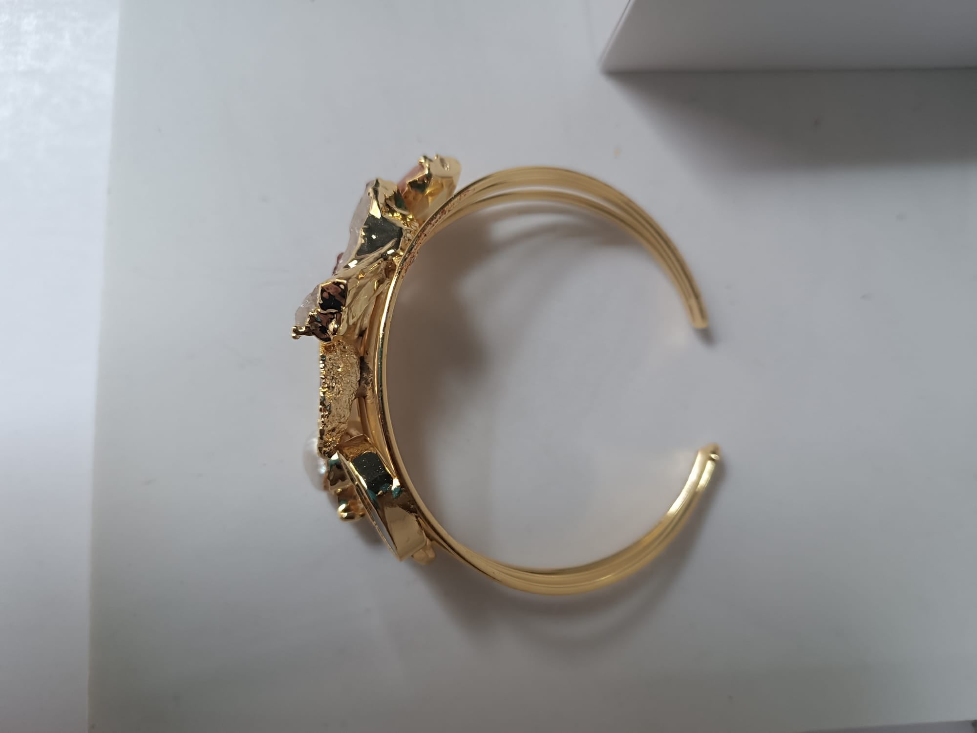 bracciale cuff dorato multifilo di Rachele Falvo con incastonati una perla barocca, un rubino grezzo, agate naturali e un'avventurina sfaccettata