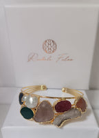 bracciale cuff dorato multifilo di Rachele Falvo con incastonati una perla barocca, un rubino grezzo, agate naturali e un'avventurina sfaccettata