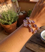 bracciale rigido aperto a fascia di Rachele Falvo in bronzo placcato oro con cristalli grezzi di ametista viola naturale