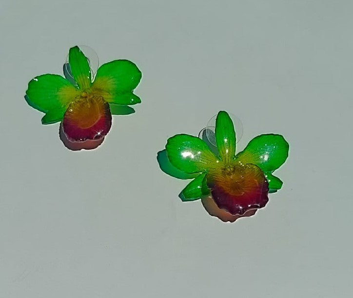 orecchini a perno artigianali realizzati con intere orchidee vere dai petali verde brillante e centro viola bordeaux, protette da resina lucida