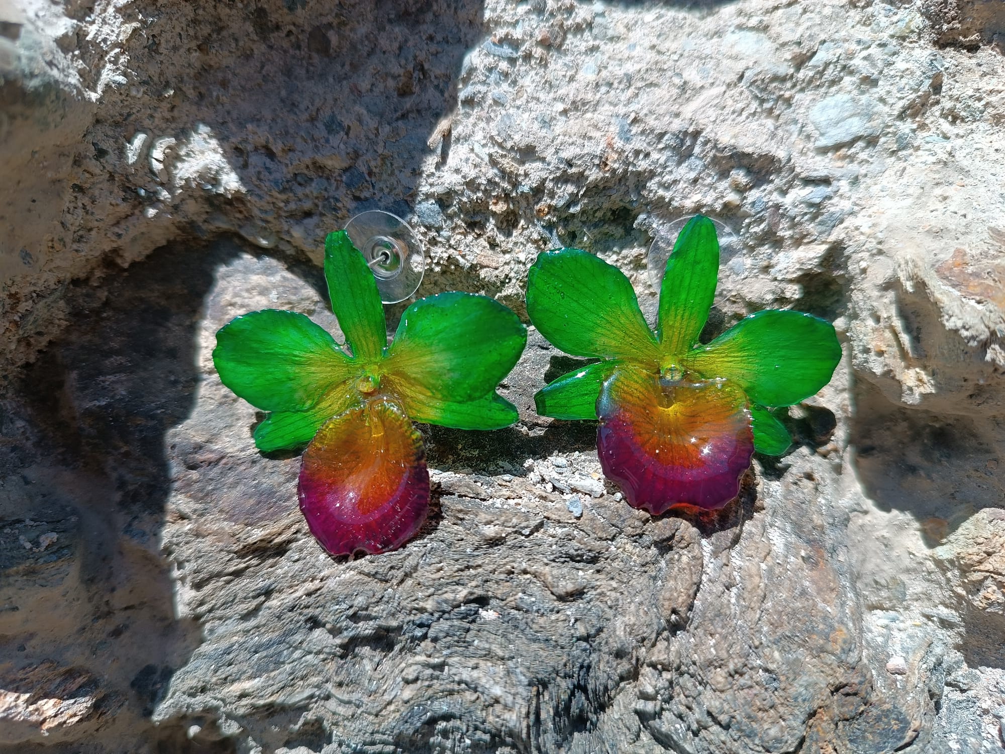 orecchini a perno artigianali realizzati con intere orchidee vere dai petali verde brillante e centro viola bordeaux, protette da resina lucida