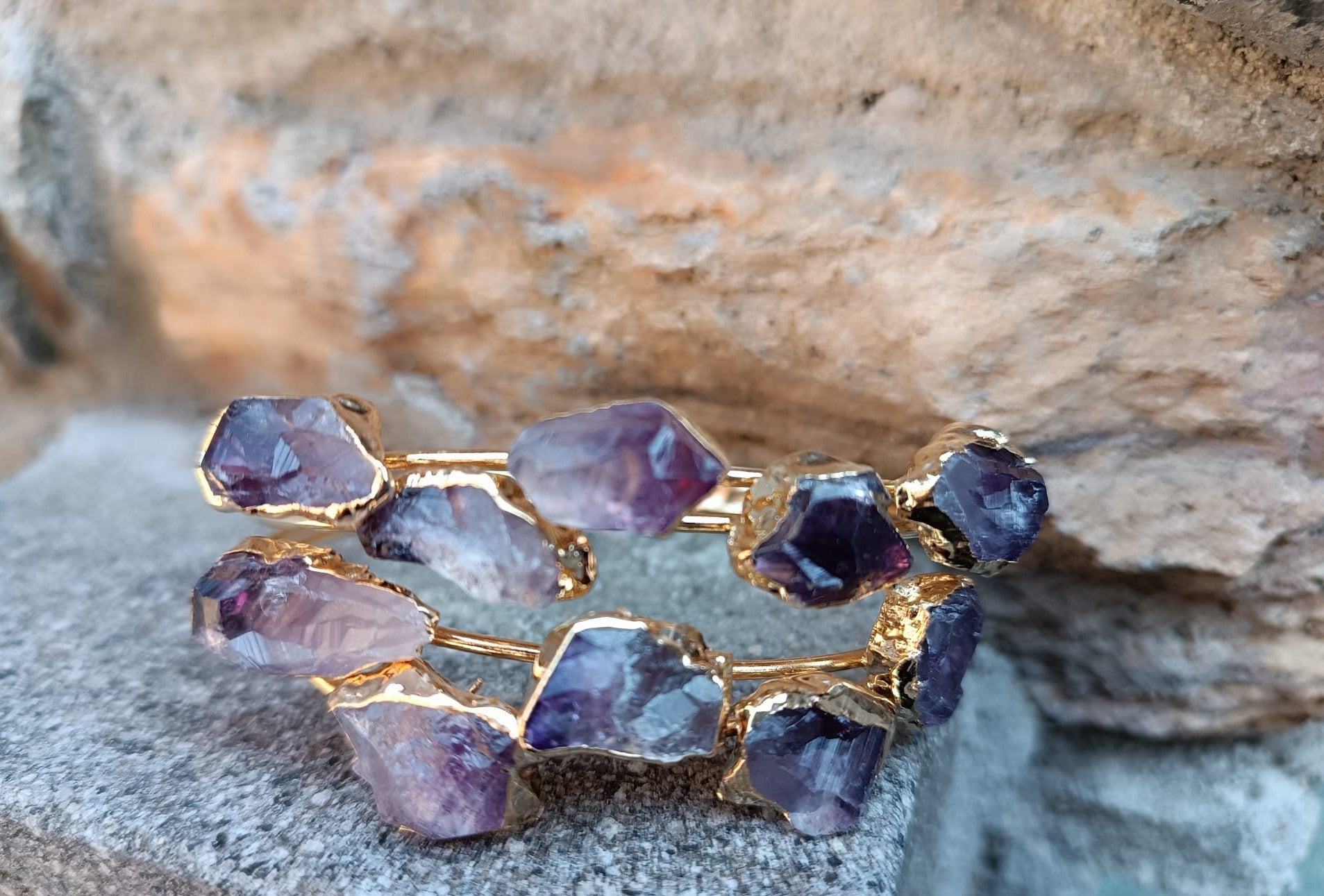 bracciale rigido aperto a fascia di Rachele Falvo in bronzo placcato oro con cristalli grezzi di ametista viola naturale