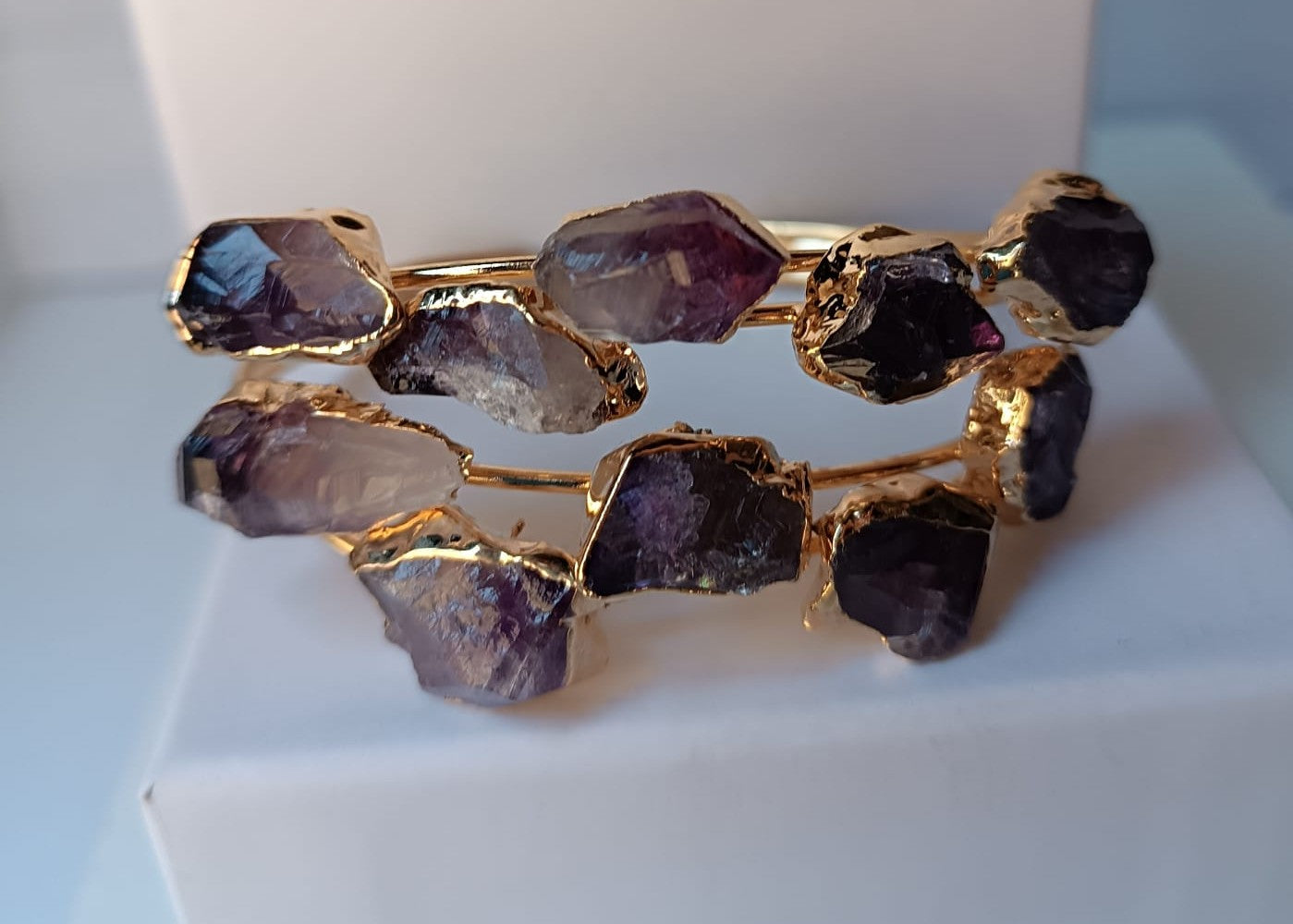 bracciale rigido aperto a fascia di Rachele Falvo in bronzo placcato oro con cristalli grezzi di ametista viola naturale