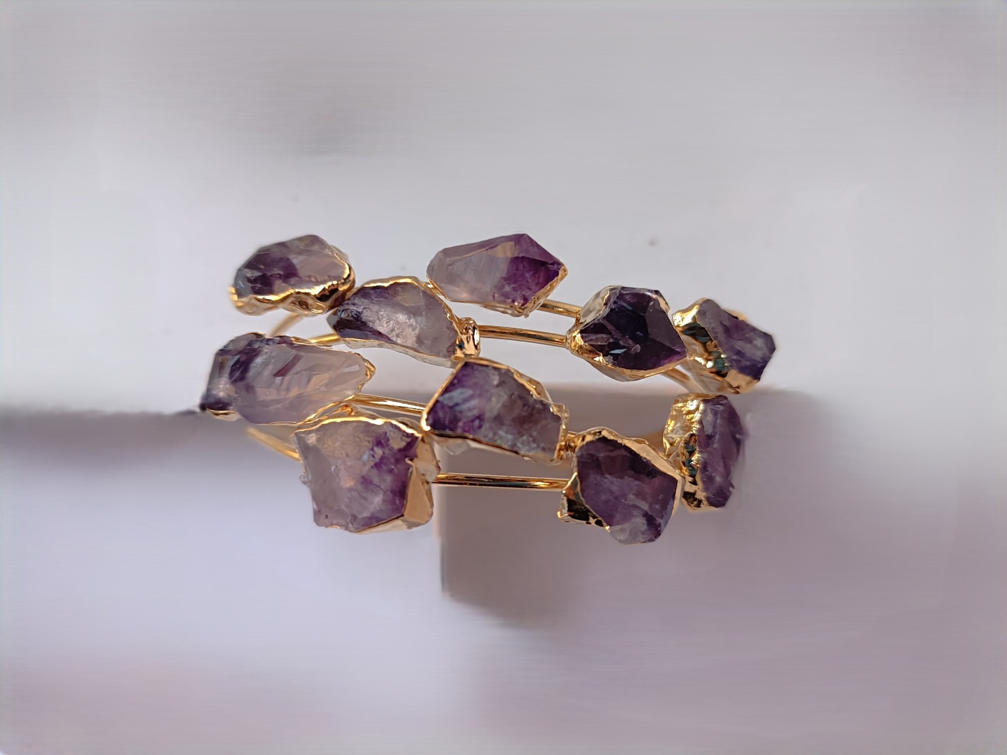 bracciale rigido aperto a fascia di Rachele Falvo in bronzo placcato oro con cristalli grezzi di ametista viola naturale