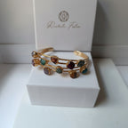 bracciale rigido a triplo filo dorato di Rachele Falvo con incastonate agate naturali multicolor