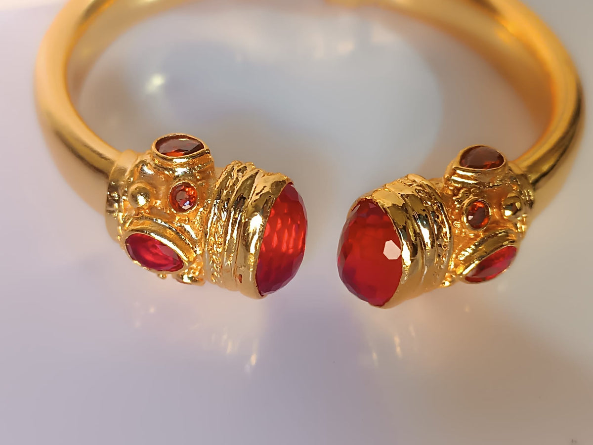 bracciale rigido in bronzo dorato a molla di Rachele Falvo in stile etrusco bizantino con intarsi e grandi diaspri rossi naturali e topazi mora