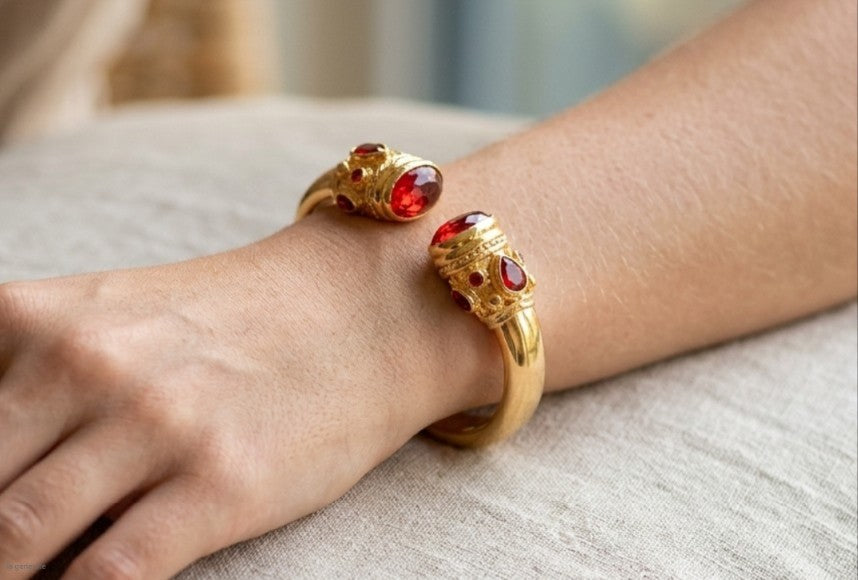 bracciale rigido in bronzo dorato a molla di Rachele Falvo in stile etrusco bizantino con intarsi e grandi diaspri rossi naturali e topazi mora