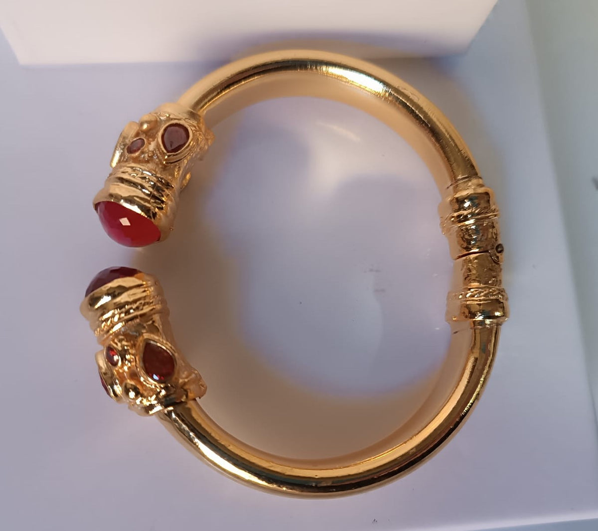 bracciale rigido in bronzo dorato a molla di Rachele Falvo in stile etrusco bizantino con intarsi e grandi diaspri rossi naturali e topazi mora