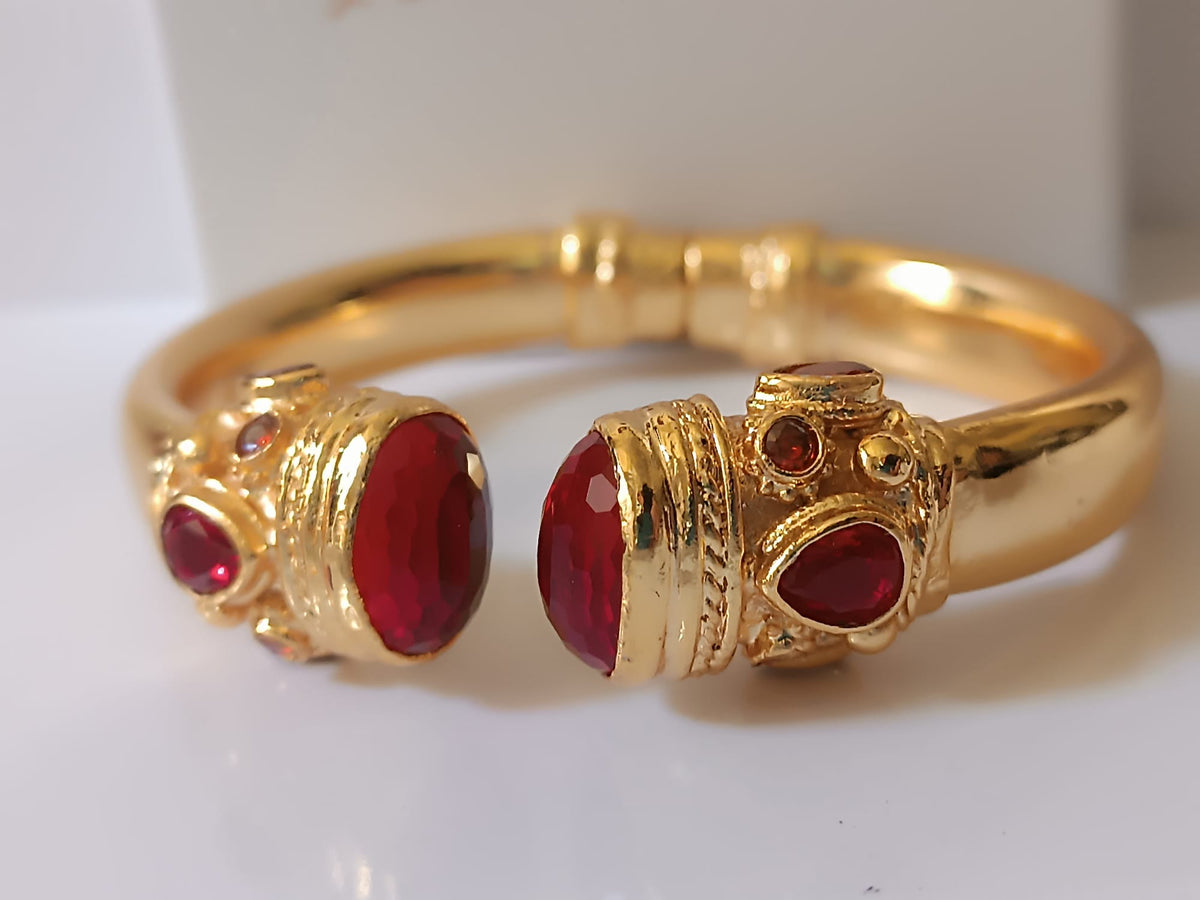 bracciale rigido in bronzo dorato a molla di Rachele Falvo in stile etrusco bizantino con intarsi e grandi diaspri rossi naturali e topazi mora