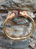 bracciale rigido in bronzo dorato a molla di Rachele Falvo in stile etrusco bizantino con intarsi e grandi diaspri rossi naturali e topazi mora