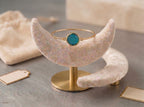 bracciale rigido in bronzo placcato oro opaco di Rachele Falvo con pietra centrale di occhio di gatto azzurro naturale sfaccettato.