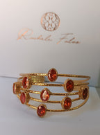 bracciale a cinque fili in bronzo dorato martellato di Rachele Falvo con incastonati nove granati rossi naturali sfaccettati da 3 carat