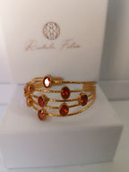 bracciale a cinque fili in bronzo dorato martellato di Rachele Falvo con incastonati nove granati rossi naturali sfaccettati da 3 carat