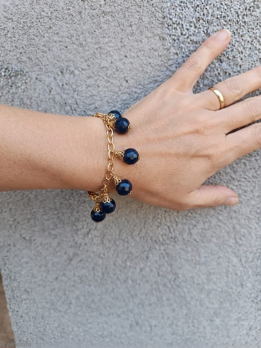 bracciale semirigido in bronzo placcato oro opaco di Rachele Falvo con fusto battuto e sei topazi azzurri naturali pendenti