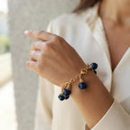 bracciale semirigido in bronzo placcato oro opaco di Rachele Falvo con fusto battuto e sei topazi azzurri naturali pendenti
