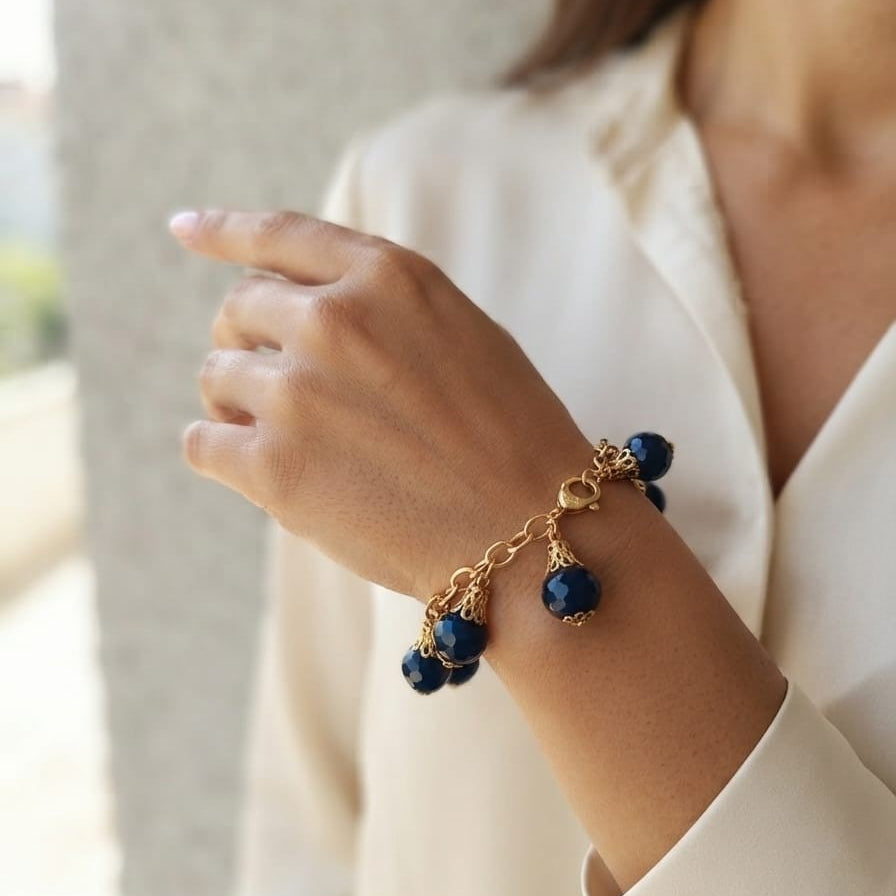 bracciale semirigido in bronzo placcato oro opaco di Rachele Falvo con fusto battuto e sei topazi azzurri naturali pendenti