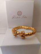  bracciale rigido scultoreo in bronzo dorato di Rachele Falvo con due teste di ariete contrapposte e fusto battuto