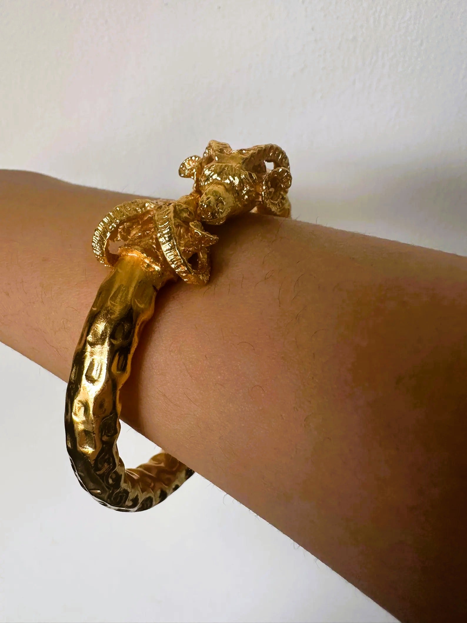 Bracciale in oro su bronzo con teste di ariete regolabile con apertura a molla