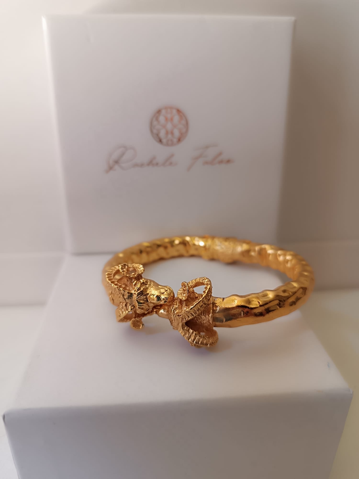  bracciale rigido scultoreo in bronzo dorato di Rachele Falvo con due teste di ariete contrapposte e fusto battuto
