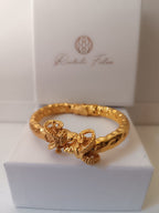  bracciale rigido scultoreo in bronzo dorato di Rachele Falvo con due teste di ariete contrapposte e fusto battuto