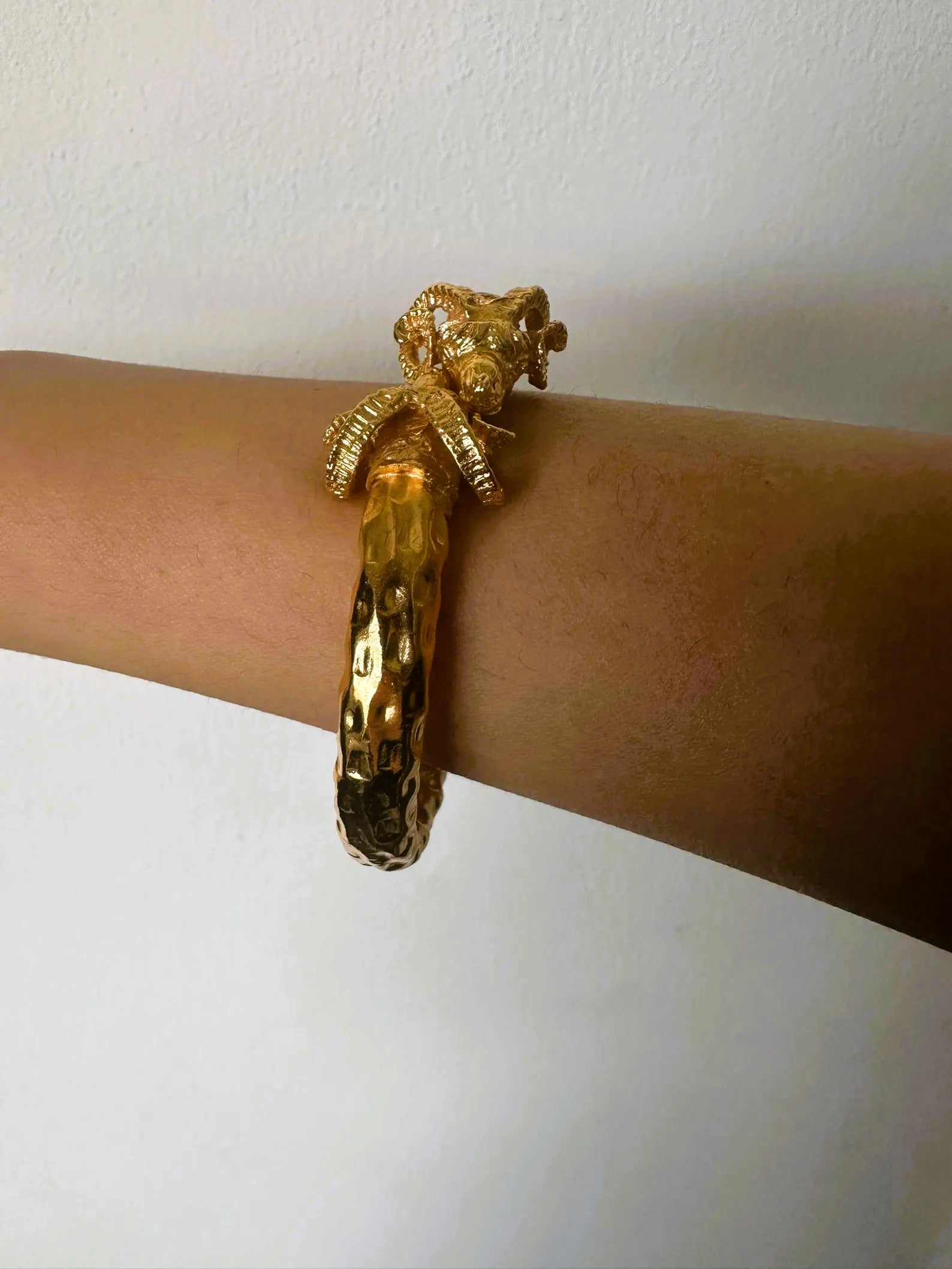 Bracciale in oro su bronzo con teste di ariete regolabile con apertura a molla
