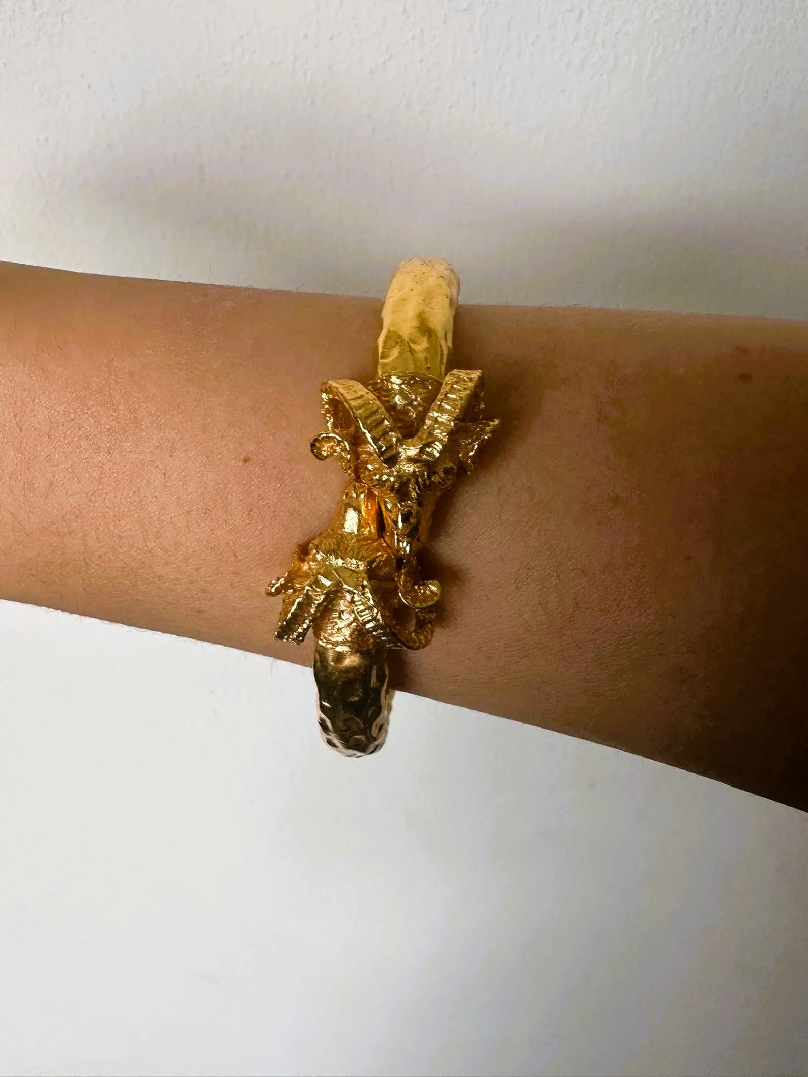 Bracciale in oro su bronzo con teste di ariete regolabile con apertura a molla