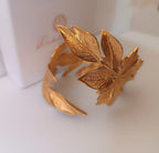 bracciale rigido alto a schiava in bronzo dorato di Rachele Falvo con grandi foglie scultoree sovrapposte