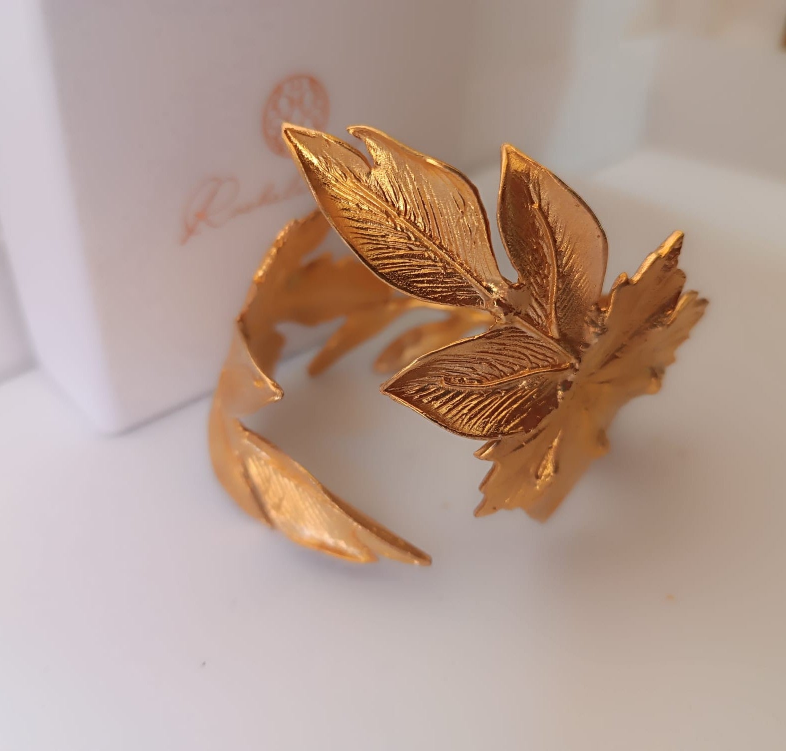 bracciale rigido alto a schiava in bronzo dorato di Rachele Falvo con grandi foglie scultoree sovrapposte