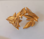 bracciale rigido alto a schiava in bronzo dorato di Rachele Falvo con grandi foglie scultoree sovrapposte