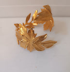 bracciale rigido alto a schiava in bronzo dorato di Rachele Falvo con grandi foglie scultoree sovrapposte