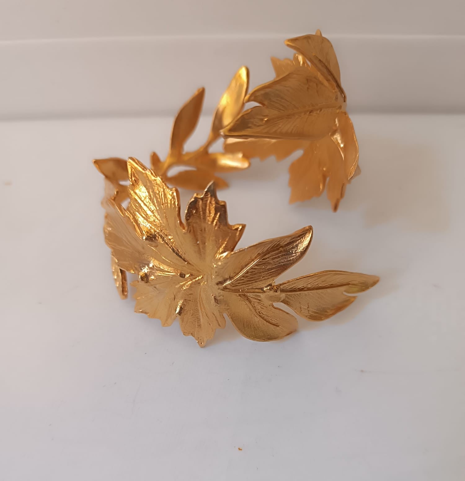 bracciale rigido alto a schiava in bronzo dorato di Rachele Falvo con grandi foglie scultoree sovrapposte