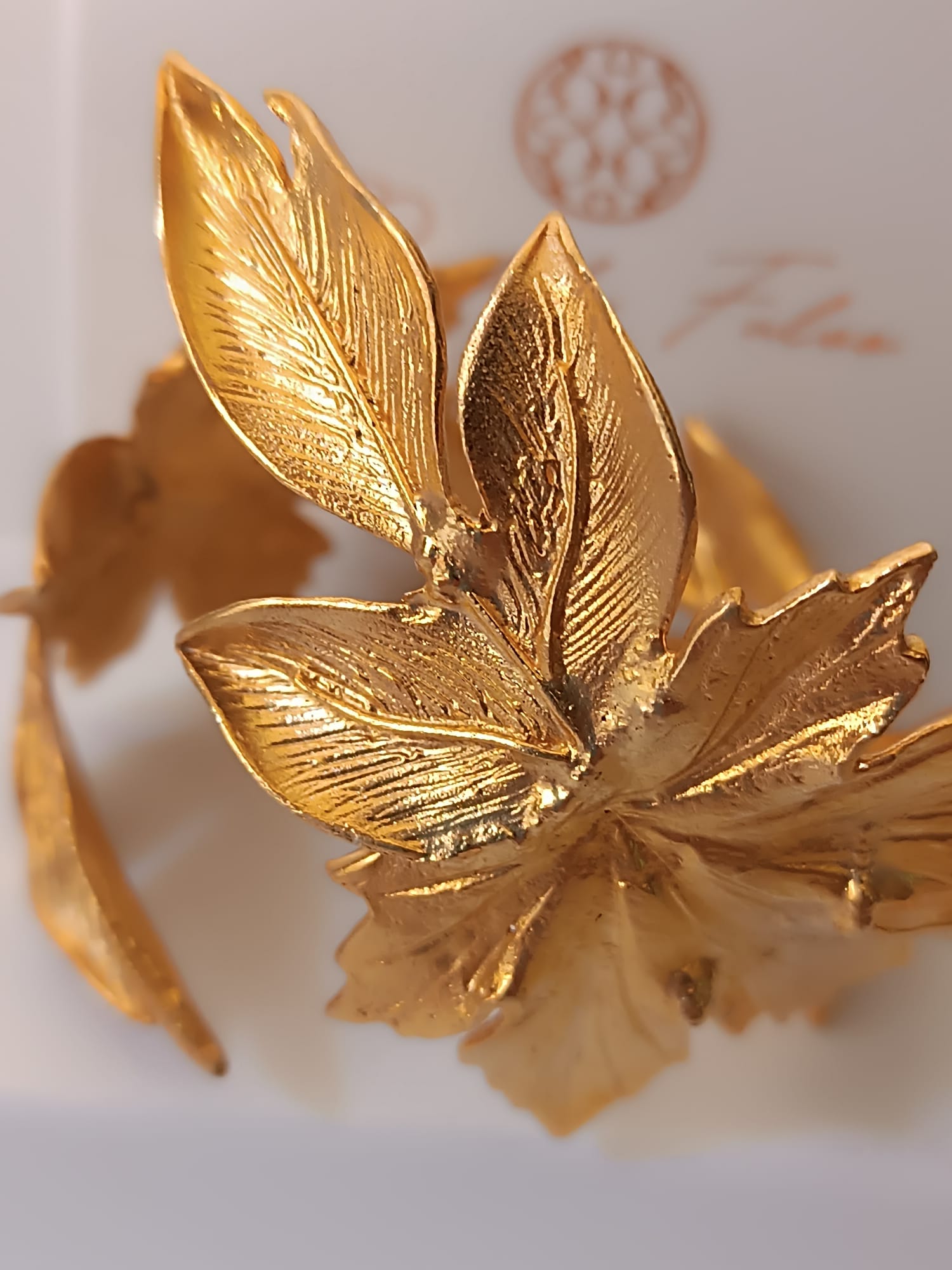 bracciale rigido alto a schiava in bronzo dorato di Rachele Falvo con grandi foglie scultoree sovrapposte