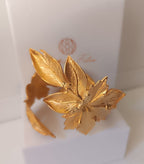 bracciale rigido alto a schiava in bronzo dorato di Rachele Falvo con grandi foglie scultoree sovrapposte