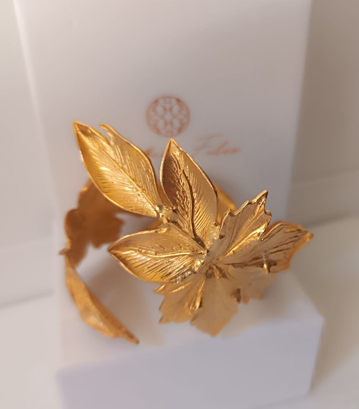 bracciale rigido alto a schiava in bronzo dorato di Rachele Falvo con grandi foglie scultoree sovrapposte