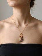 Collana in bronzo dorato con pendente bizantino incastonato con tormalina rosa e topazi naturali