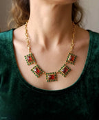 Spettacolare collana girocollo artigianale in bronzo oro opaco con elementi geometrici incastonati di giade verdi e quarzi rosso arancio sfaccettati.