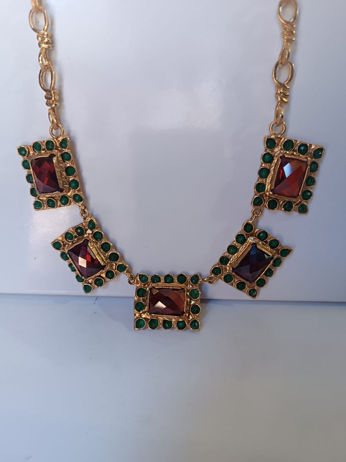 Spettacolare collana girocollo artigianale in bronzo oro opaco con elementi geometrici incastonati di giade verdi e quarzi rosso arancio sfaccettati.