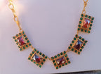 Spettacolare collana girocollo artigianale in bronzo oro opaco con elementi geometrici incastonati di giade verdi e quarzi rosso arancio sfaccettati.